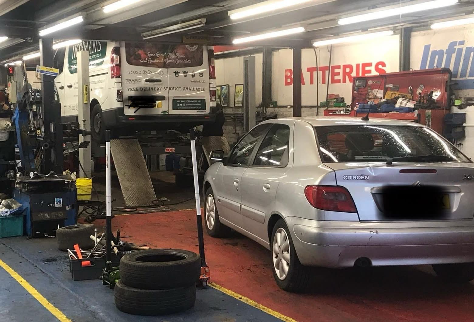 Car on hydraulic lift in workshop